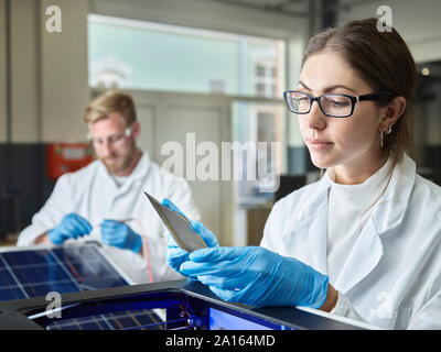 Two technicians working on solar cell in lab Stock Photo