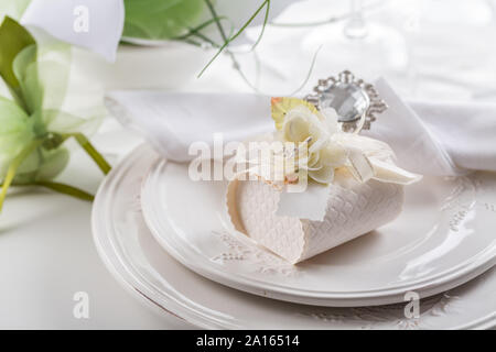 Festive table setting with small gift on plate Stock Photo