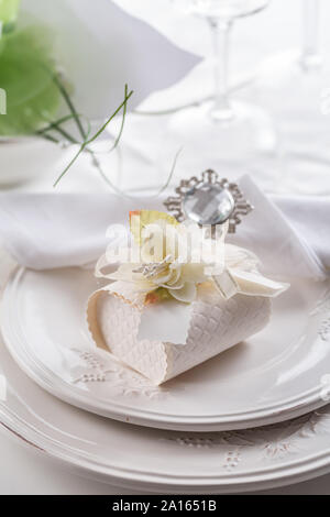 Festive table setting with small gift on plate Stock Photo