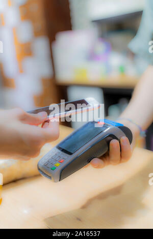 Customer paying cashless with smartphone in a shop Stock Photo