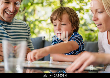 Happy parents and son playing a board game on terrace Stock Photo