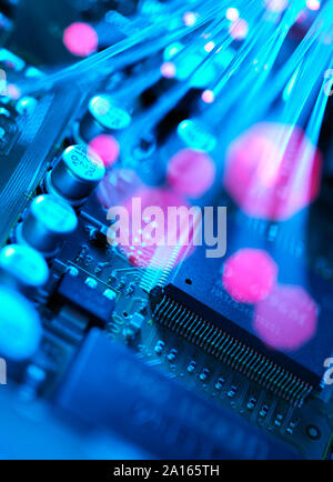 Fibre optics carrying data passing across electronic circuit board Stock Photo