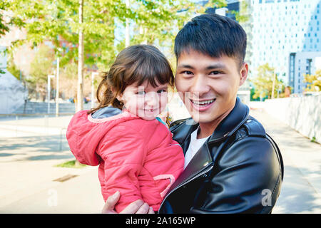 Portrait of happy father holding little daughter Stock Photo