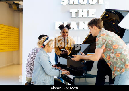 Students havig fun, playing a piano together Stock Photo