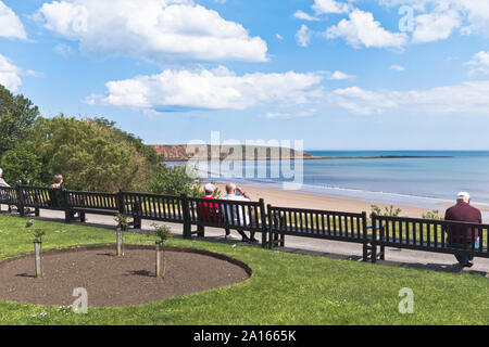 dh Royal crescent gardens FILEY NORTH YORKSHIRE Couple people sitting relaxing overlooking The Brigg Stock Photo