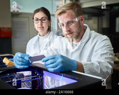 Two technicians working on solar cell in lab Stock Photo