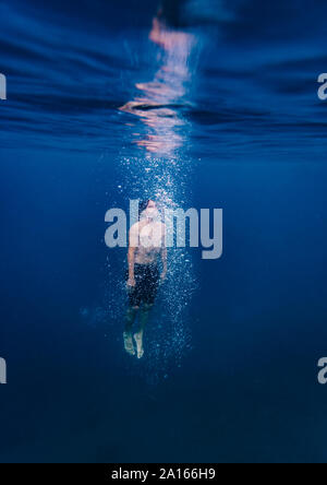 Young man diving underwater Stock Photo