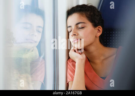 Teenage girl traveling alone by train, sleeping Stock Photo