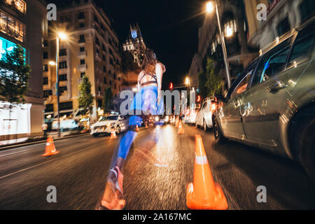 Woman running in Madrid city with flashing lights at night Stock Photo