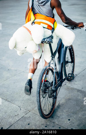 Bicycle courier delivering a teddy bear Stock Photo