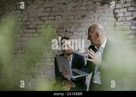 Senior and mid-adult businessman having a meeting using laptop Stock Photo