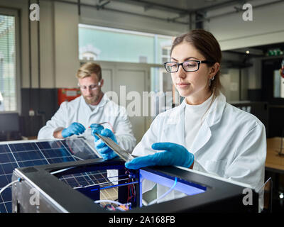 Two technicians working on solar cell in lab Stock Photo