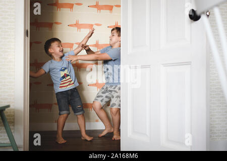 Two brothers play fighting at home Stock Photo