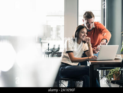 Casual businessman and woman with laptop meeting in office Stock Photo