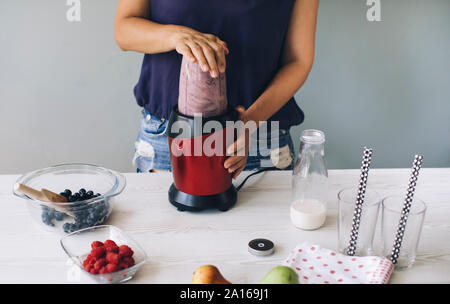 Woman making smoothie in a blender