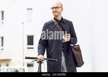 Man with bicycle going to work holding his smartphone Stock Photo