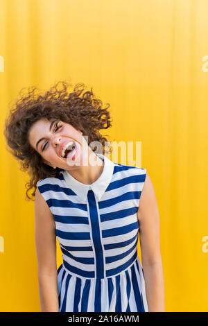 Portrait of young woman shaking her head, yellow background Stock Photo