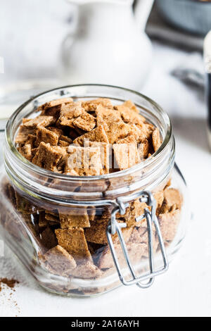 High angle view of fresh homemade baked cinnamon cereals in open jar on table Stock Photo