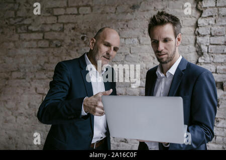 Senior and mid-adult businessman having a meeting using laptop Stock Photo