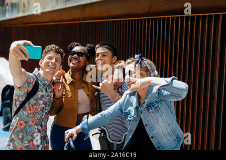 Students standing in the street, taking selfies Stock Photo