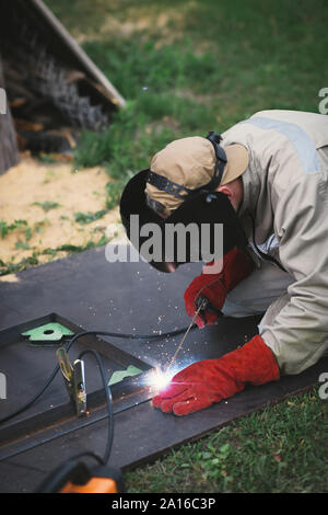 Man welding metal in his backyard Stock Photo