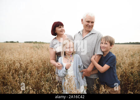 Portrait of grandparents with their grandchildren in an oat field Stock Photo