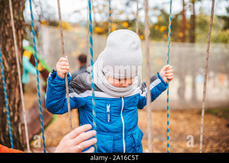 father with toddler kid son playing at playground autumn season Stock Photo