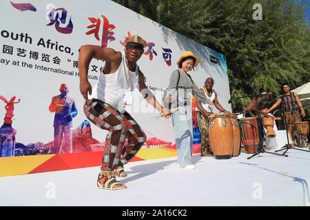 (190924) -- BEIJING, Sept. 24, 2019 (Xinhua) -- Artists interact with a visitor during the 'South African Heritage Day' event of the Beijing International Horticultural Exhibition in Beijing, capital of China, Sept. 24, 2019. The expo held its 'South African Heritage Day' event on Tuesday. (Photo by Duan Xuefeng/Xinhua) Stock Photo