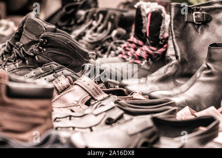Pairs of worn shoes photographed in sepia filter. Stock Photo
