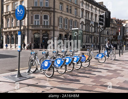 dh Cycle hire BIKES TRANSPORT Man using Pay as you go bicycle scheme Cardiff Wales bike for hiring uk Stock Photo