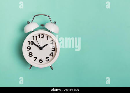 Vintage alarm clock isolated on pastel mint background, Stock Photo