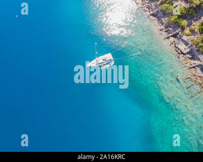 Sailing yacht moored to the shore, a delightful seascape drone photo. Clear blue sea. Sailing regatta, boat trip, top view Stock Photo