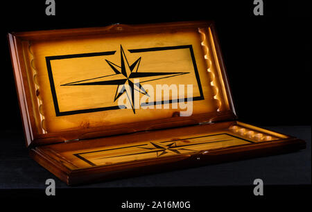 Open backgammon board over a dark background. A beautiful board for an old backgammon game. Stock Photo