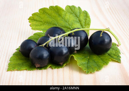 berries of ripe black currant on wooden background, closeup Stock Photo