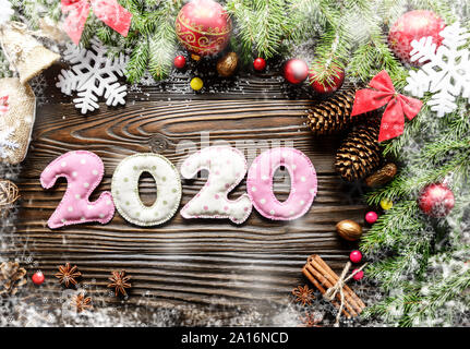 Colorful stitched digits 2020 of polkadot fabric with Christmas decorations flat lay on wooden background Stock Photo