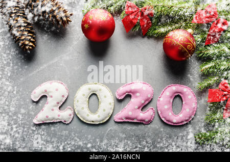 Colorful stitched digits 2020 of polkadot fabric with Christmas decorations flat lay on stone background Stock Photo