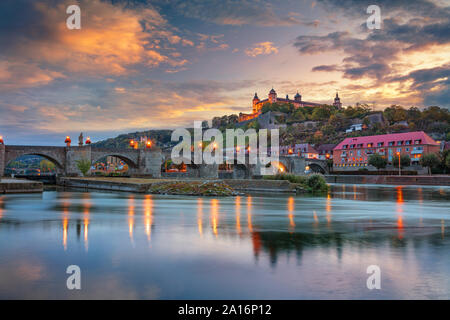 Wurzburg, Germany. Cityscape image of Wurzburg with Old Main Bridge over Main river and Marienberg Fortress during beautiful autumn sunset Stock Photo