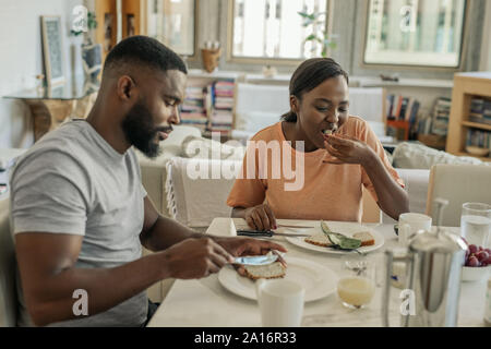 Young African American couple sitting at home eating breakfast Stock Photo