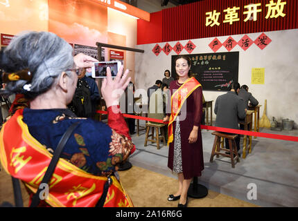 (190924) -- BEIJING, Sept. 24, 2019 (Xinhua) -- Yang Xiaoling, an ethical role model who works as deputy head of a school for students with hearing and speech impairment in Wuhan, poses for photos during a grand exhibition of achievements in commemoration of the 70th anniversary of the founding of the People's Republic of China (PRC) at the Beijing Exhibition Center in Beijing, capital of China, Sept. 24, 2019. More than 200 role models from across the country were invited to tour a grand exhibition in Beijing Tuesday. Among them were ethical role models and elite cultural figures, including Stock Photo