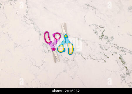 Blue and pink scissors on the table Stock Photo