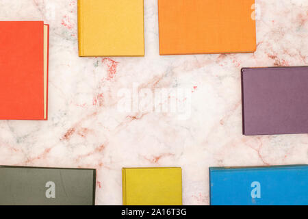 Books in different colors on the table and empty space in the middle for your text or title Stock Photo