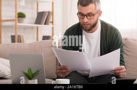 Man holding documents with both hands, reading it Stock Photo