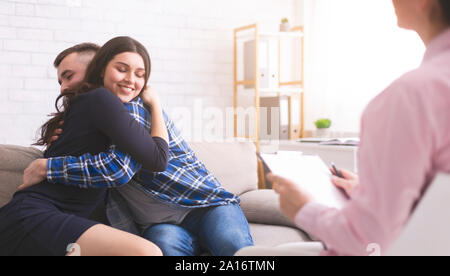 Happy spouses embracing during professional marital consultation Stock Photo