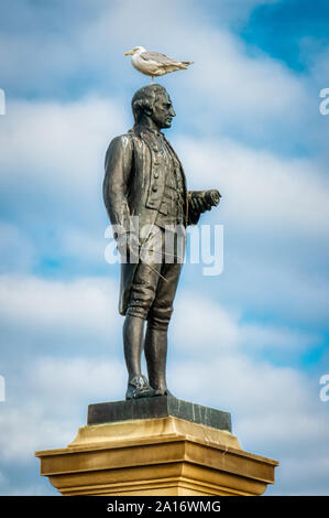 Captain Cook memorial with seagull perched on his head, Whitby, North Yorkshire, UK Stock Photo