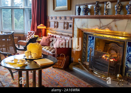 Cosy fire in the sitting room at Cragside House, Northumberland, UK Stock Photo