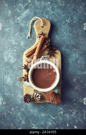 Hot chocolate with winter spices on  wooden kitchen board. Flat lay. Still life Stock Photo