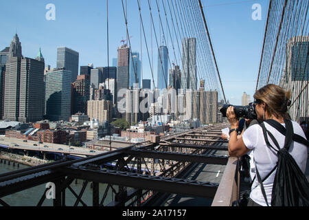Woman taking pictures from Brooklyn Bridge of Pier 17, South Street Seaport und Manhattan Skyline, New York City Stock Photo