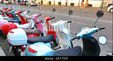 Editorial Rome, Italy - 16th june 2019: The iconic Vespa scooters lined up ready for use in front of a Vespa rental shop. Stock Photo