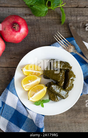 Grape leaf filled with rice served with lemon. Traditional Greek food Stock Photo