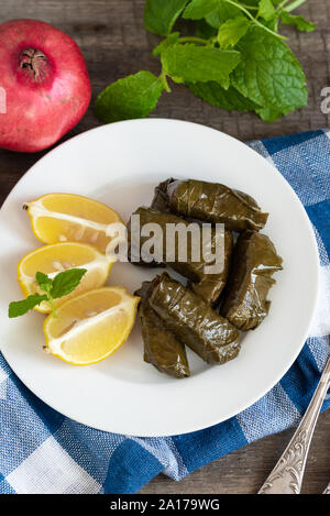 Grape leaf filled with rice served with lemon. Traditional Greek food Stock Photo